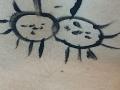 Un croquis de deux formes ressemblant à des soleils, avec des lignes noires et des visages simples, présentant de petits yeux et des bouches. La poitrine poilue d'OrianaLaFrancaise se trouve en bas au premier plan..