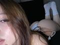 TaniaRaffa lying on her stomach, white socks, brown hair, visible ass, white panties, slightly parted lips, looking to the side, bedroom setting, soft lighting, relaxed pose.