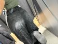 MargoFun's ass in dirty black pants with dark, smudged patterns. She's wearing green shirt, black socks, and a belt with a keycard. Her backpack is on the left.
