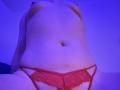 HornnyCoupleHot's bare tits and red lace panties, showing a soft belly and a small navel, with blue lighting, taken from a low angle.