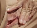 FrenchieLilieFleur's pussy, with her fingers spreading her labia to reveal her pink, wet, and slightly open vagina. She's wearing a gold ring on her right hand.