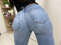 OliviaGranda's blue jeans butt is prominent, showing two back pockets and a tight, denim texture. Her black lace top is visible at the waist.