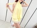 JuliannaMoor in a yellow halter dress, holding the strap, showing her small ass and white sneakers with a playful pose, red hair, and a cute smile.
