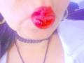 MissGilliSquirty's red, glossy pout is centered in the frame, with a black bead necklace and a white shirt partially visible, showing her gold hoop earrings.