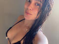 MaiaPark with wet brown hair, black bra showing her tits, subtle smile, light skin, small gold necklace, soft sunlight on her face.