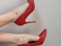 Tattiya's pale legs in red, croc-pattern high heels, with heels pointed upwards, showing off her sexy, slender feet and pointed toes. The red heels are a major butt-look.