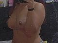 EmilyEvan's topless mirror selfie shows her wet, medium-sized tits with nipples visible, holding her phone with her right hand, red hair, black bracelet, and wet skin in dark background.