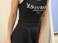 Rorria's black tank top and high-waisted black skirt, showing her bare arms and a small part of her tits, with a black and white text on the top.