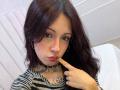 ValeryBeaumont with dark red hair, freckles, and pink lips, sucking on her finger, wearing a striped shirt, choker, and a heart tattoo on her chest.