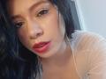 LindaMancini has a sexy face with red lipstick, glossy eyes, and black wavy hair. She's wearing a sheer white top, showing her soft skin and subtle cleavage.