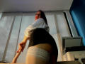 SweettEve in white shirt and black skirt, bending over with her ass up, wearing white lace thigh-highs, holding a wand in a sunlit room with a printer.