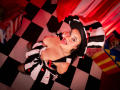 IsabellaVoss in a black and white striped witch outfit with red heart accents, her big tits exposed, looking up with her tongue out, wearing a black hat.