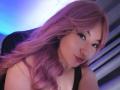 SusanMonroy with pink hair, black tank top, and subtle makeup, showing her face and upper chest, looking at the camera with a slight smile. Her tits are partially visible.