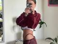 HotCaramelsTrio with a flat stomach, wearing a maroon zip-up jacket, white underwear, and maroon pants, taking a mirror selfie, exposing a thong and a slim, toned body.