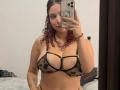 ValeryScot with curly red hair, wearing a black sheer bra with star patterns, showing her tits in a mirror selfie. She's holding a phone, looking at the camera.