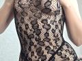 Strogoff's bare skin is visible through a black lace patterned bodysuit, showing her tits and a hint of her pussy. The lace is floral and she's in a seductive pose.
