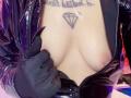 LaurenEvie69's tits are exposed with black latex gloves pulling open her shiny black leather jacket, revealing a diamond tattoo above her bare breasts.