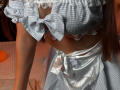 Euphorias' checkered, frilled, grey-blue maid dress with lace, showcasing her tits, and a shiny silver apron tied at the waist, with her brown hair visible.