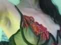 ZarayFeet with bare armpit, wearing a green sheer bra with red floral embroidery, showing small tits and a bit of cleavage. Long black hair on right.
