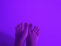 MargoFun's feet are up, showing her toes with purple-tinted skin against a solid purple background, highlighting her slightly dirty toenails.