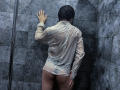 RubyMote with wet black hair, wearing a transparent white shirt, exposing her bare ass, standing against gray tile walls, hand on wall, in a dimly lit shower.