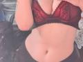 DarylSanks has a red and black lace bra, showing her tits and a tattoo on her arm, with a flat, sexy, and slightly curvy belly.
