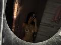 Nude MajoJones with dark hair, tattoos, and medium-sized tits, covering one breast with her hand, taking a mirror selfie in a dimly lit bathroom.