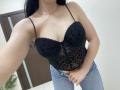 OliviaGranda with black, lace-up, leopard-print bustier, showing her tits, wearing blue jeans, holding her crotch, long dark hair, silver necklace, and bracelet, in a selfie.