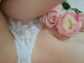 AmeliaMaiv's lace-covered pussy, with white floral lace, showing a pink and yellow rose on her lower belly. Soft, pale skin, intimate, sensual.
