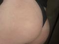 Barbarica's ass in black panties, showing a slight scar on her right buttock, with a visible tan line. Her skin is light and slightly textured.
