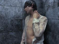 RubyMote with wet black hair, shirt clinging to his chest, exposing his flat ass and small, hard, flaccid dick, standing in a dark gray tiled shower.