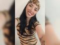 MartinaRey has black hair, wearing a leopard print headscarf and zebra-striped top, smiling with red lipstick, showing a tattoo on her right arm, in a selfie.