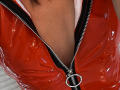 Red shiny puffy vest, zipped down to reveal Euphorias' chest, showing brown skin and a bit of dark hair. Metal zipper ring in the center.