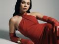 Hannu's red dress, halter style, showing her tits, with matching red gloves, lying down, wearing a gold bracelet, black hair, light skin, looking at camera.