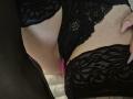 Rouzi's black lace lingerie, showing her pussy with a pink butt plug, her hand with manicured nails on the right. Her skin is pale and she's wearing lace thigh-highs.