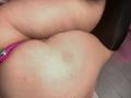Il sedere di AmaraKazumi con un vibratore rosa inserito parzialmente. La sua pelle è pallida con un leggero segno rosso. È sdraiata su una superficie scura..