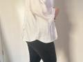 Elliance's white shirt, black pants, and soft curves. Her hand rests on her hip, showing off her butt. The image focuses on her lower body.
