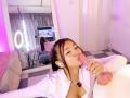 AlessiaFerry, with white earbuds in, is sucking a large, pink, erect cock. She's wearing a white shirt, and her brown hair is in a ponytail. Reflection in mirror.
