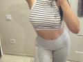Olieri has big tits in a striped crop top, showing her belly button with a piercing, wearing tight grey leggings, in a mirror selfie.