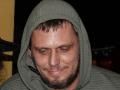 FrancimooR has a sweaty, slightly grinning face with a green hood, brown beard, and short hair, wearing a ribbed green hoodie, looking forward with half-closed eyes.