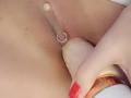 FrenchShanna's pussy with a silver ring on her clit, being gently spread by a pink-tipped dildo held by her red-manicured hand.