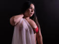 SalomettX with dark hair, red lace bra, and sheer white cloth covering her tits, has a confident expression, wearing a bracelet against a dark background.