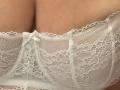 MargoFun's white lace bra shows her big tits, detailed with floral patterns and a small white bow in the center. Her light skin is visible above the lace.