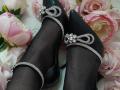 AmeliaMaiv's black pointy-toe shoes with silver sparkly straps and rhinestones, covered in sheer black stockings, lying on pink and white roses.