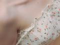 TeresaBirt's tits in a white, floral-patterned, ruffled, ribbed, strapless top. Her fair skin is visible, showing a soft, smooth, and slightly pinkish tone.