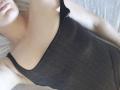 WilsonMelania's chest is showing in a black, slightly shiny tank top, with a visible black strap and her arm raised. Her face is partially in the frame.