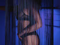 MilenaBaldwin with dark black lingerie, standing sideways, her tits and ass visible through blue-tinted bead curtains, hands near her crotch, slim and sexy, glowing under soft blue light.