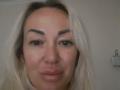 MysteryLaddy has blonde hair, thick eyebrows, and is pouting with slightly parted lips. She has green eyes and a light skin tone. Her ass is not visible.