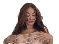 Paulatina with brown wavy hair, looking down, wearing a netted top, covering her tits with hands, gold necklace, mint green nails, white background.