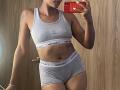 RoldanStefy in gray Calvin Klein underwear, showing a toned, tan-skinned body with small tits, a flat stomach, and a tattoo on the left shoulder. Reflecting in a mirror.